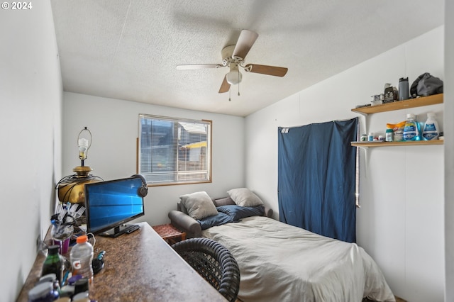 bedroom featuring ceiling fan and a textured ceiling