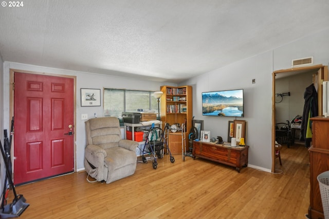 sitting room with wood-type flooring and a textured ceiling