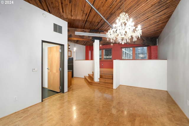 unfurnished dining area with a towering ceiling, a notable chandelier, and wood ceiling