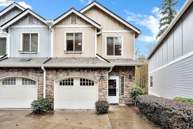 2067 NE 49th Way, Hillsboro, OR 97124 - view of front of house with stone siding, driveway, board and batten siding, a garage, and roof with shingles