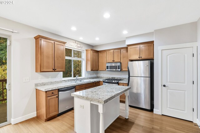 2067 NE 49th Way, Hillsboro, OR 97124 - kitchen with appliances with stainless steel finishes, a sink, light wood-type flooring, a center island, and baseboards