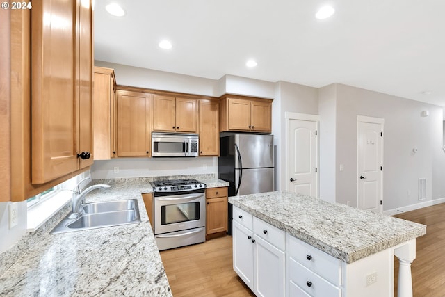 2067 NE 49th Way, Hillsboro, OR 97124 - kitchen with stainless steel appliances, a sink, light wood finished floors, a kitchen island, and recessed lighting