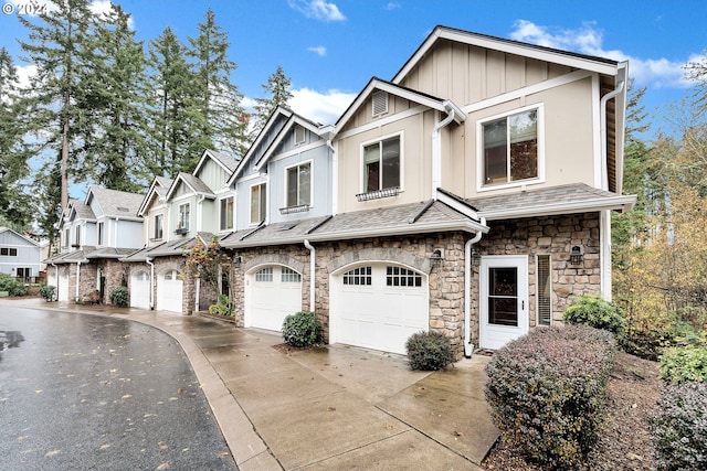 2067 NE 49th Way, Hillsboro, OR 97124 - view of property featuring driveway, stone siding, an attached garage, and board and batten siding