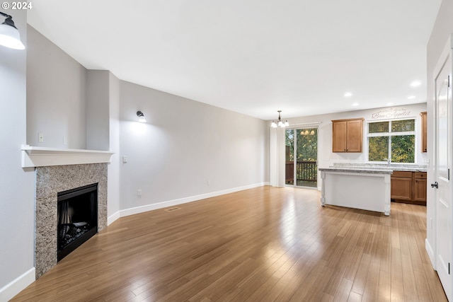 2067 NE 49th Way, Hillsboro, OR 97124 - unfurnished living room featuring a chandelier, light wood-style flooring, a fireplace, recessed lighting, and baseboards