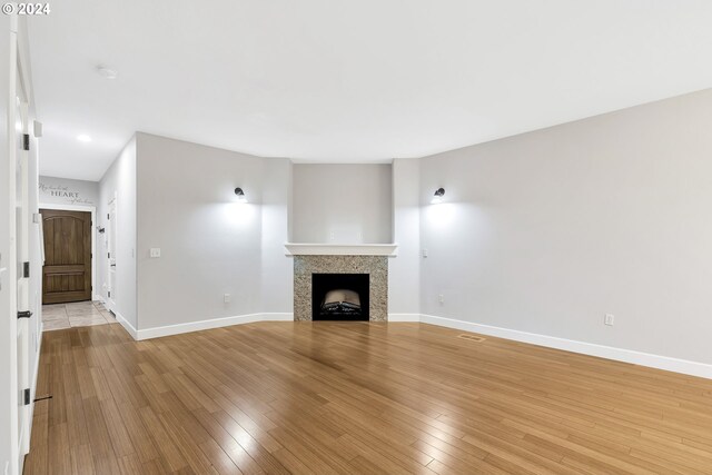 2067 NE 49th Way, Hillsboro, OR 97124 - unfurnished living room featuring baseboards, light wood-type flooring, a fireplace, and recessed lighting