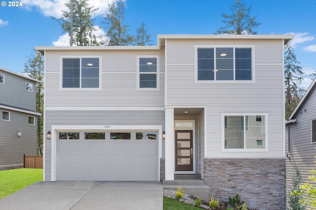 view of front of home with stone siding, concrete driveway, and an attached garage