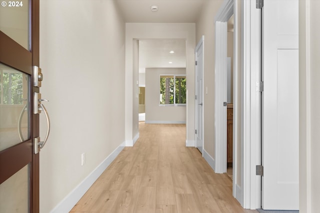 hallway featuring light wood-style floors, recessed lighting, and baseboards