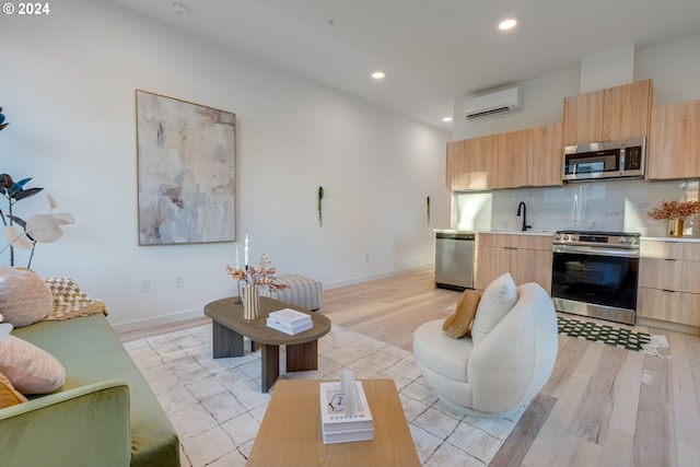 living room with an AC wall unit, light tile patterned floors, and sink