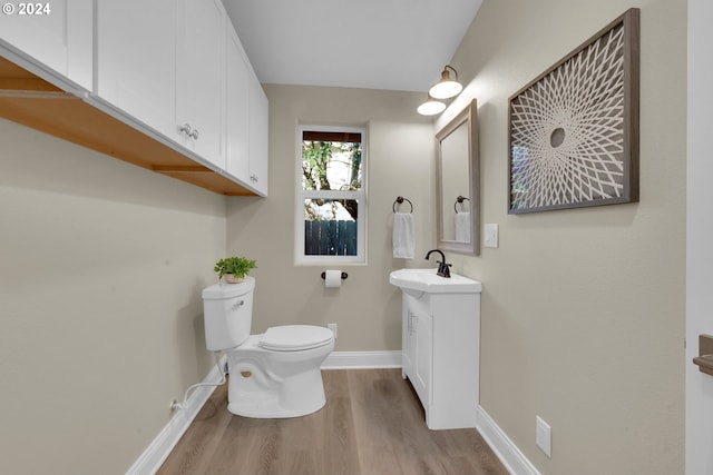 bathroom with vanity, hardwood / wood-style flooring, and toilet