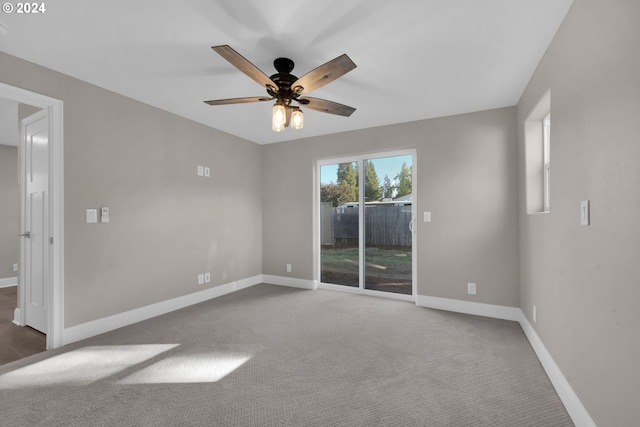 empty room with ceiling fan and dark colored carpet