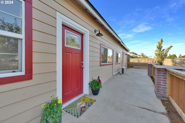 view of exterior entry with a patio and central AC unit