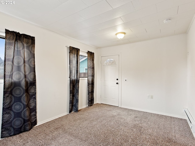 carpeted spare room with crown molding and a baseboard heating unit