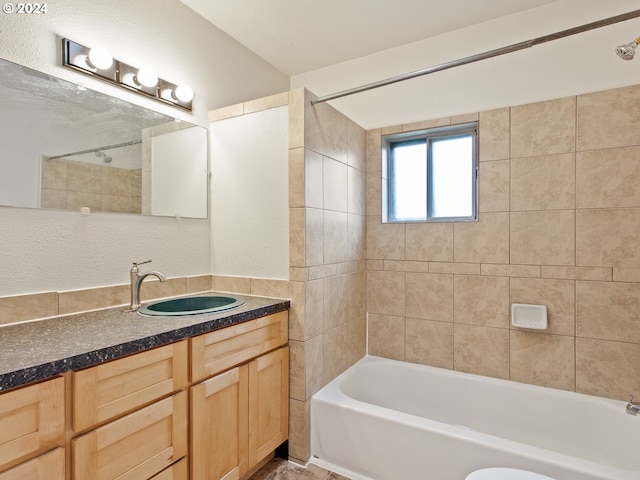 full bathroom featuring tiled shower / bath combo, toilet, and vanity