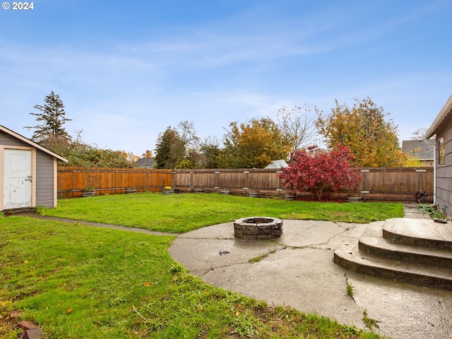 view of yard featuring a shed and an outdoor fire pit