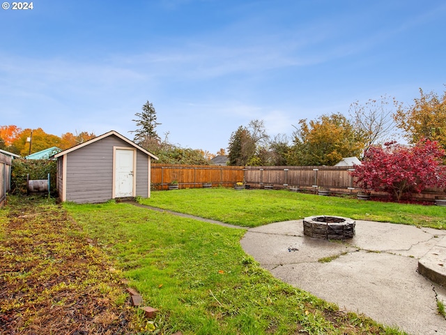 view of yard featuring a shed and an outdoor fire pit