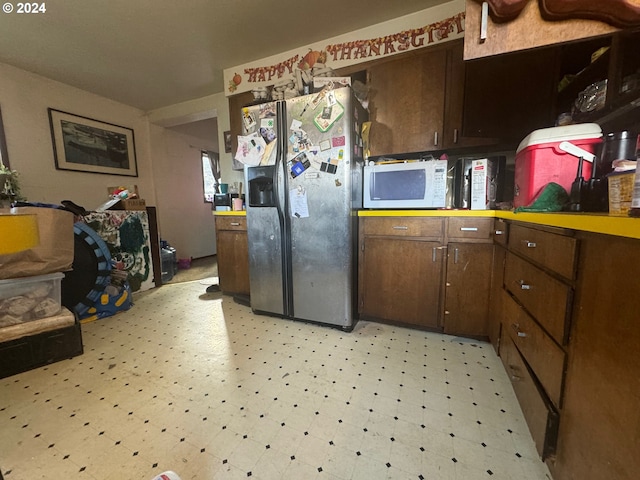 kitchen with stainless steel refrigerator with ice dispenser and dark brown cabinetry