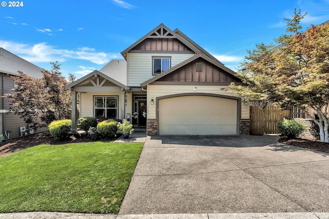 craftsman inspired home featuring a garage and a front lawn