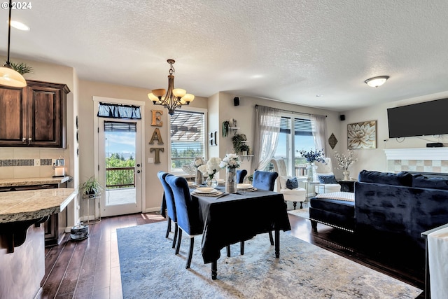 dining room with dark hardwood / wood-style floors, a notable chandelier, and a textured ceiling