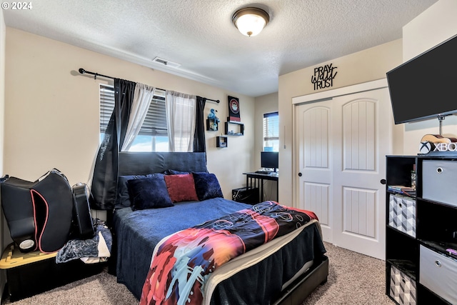 bedroom featuring a textured ceiling, a closet, and light colored carpet