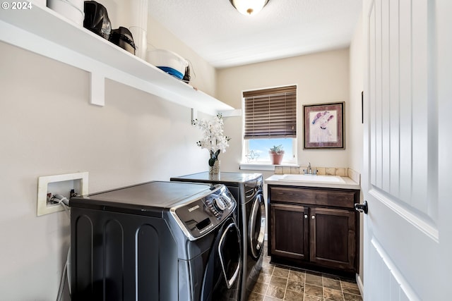 laundry room featuring cabinets, independent washer and dryer, sink, and dark tile patterned flooring