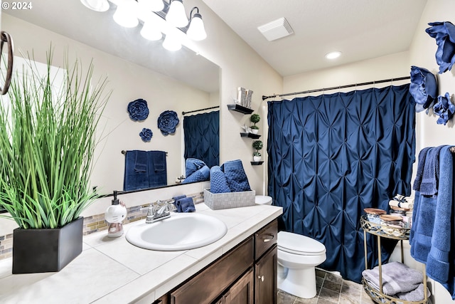 bathroom featuring vanity, curtained shower, and toilet