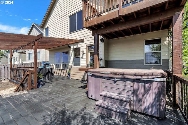 deck with a pergola and a hot tub