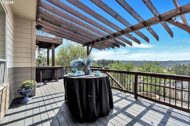 wooden deck featuring a jacuzzi and a pergola