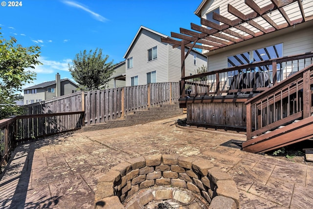 view of patio with a wooden deck, a fire pit, and a pergola