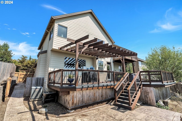 rear view of house featuring a wooden deck, a pergola, and a patio area