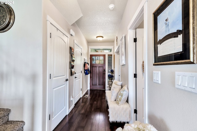 entryway with dark wood-type flooring and a textured ceiling