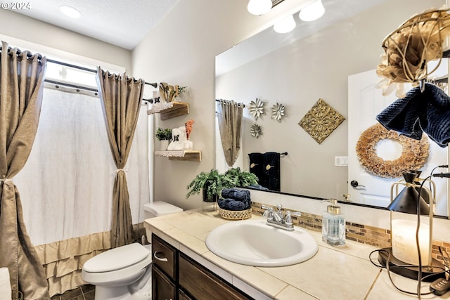 bathroom featuring tile patterned floors, vanity, and toilet