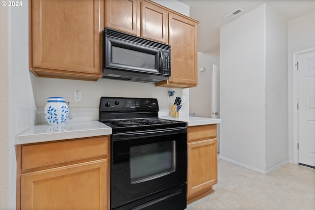 kitchen with tile countertops and black appliances