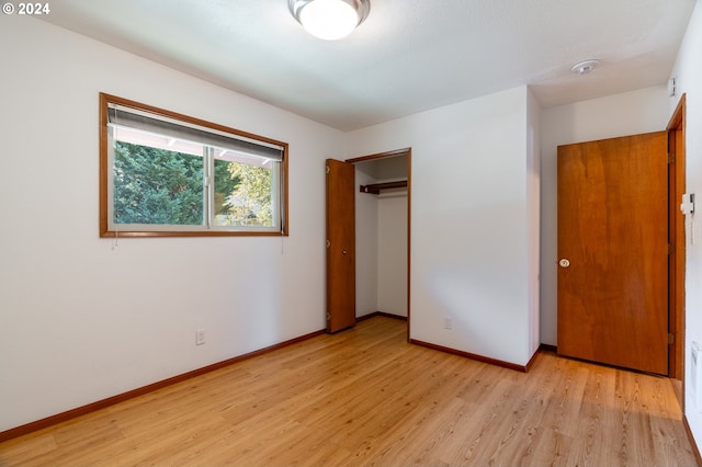 unfurnished bedroom with a closet and light hardwood / wood-style floors