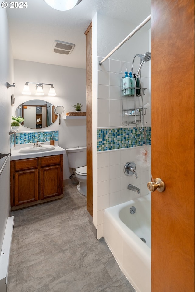 full bathroom with tiled shower / bath combo, toilet, and vanity