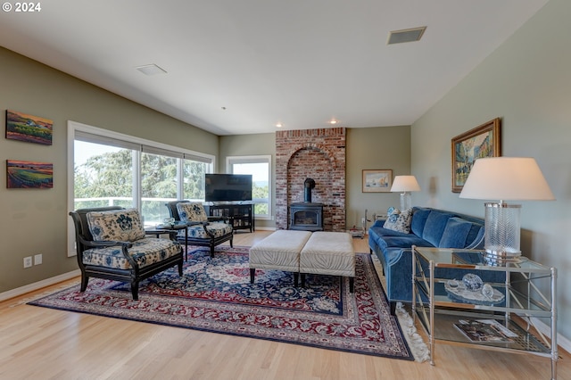 living room featuring hardwood / wood-style floors, a wood stove, and a wealth of natural light