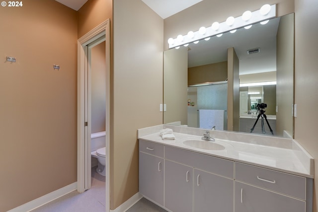 bathroom with vanity, toilet, and an enclosed shower