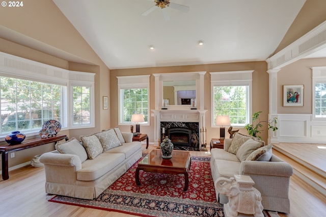 living room featuring lofted ceiling, a premium fireplace, and plenty of natural light