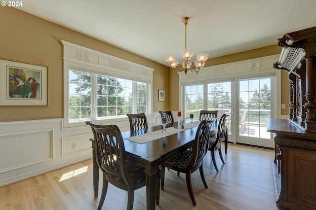 dining area featuring an inviting chandelier, a wealth of natural light, and light wood-type flooring