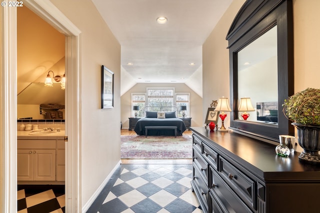 corridor featuring sink, light tile floors, and lofted ceiling