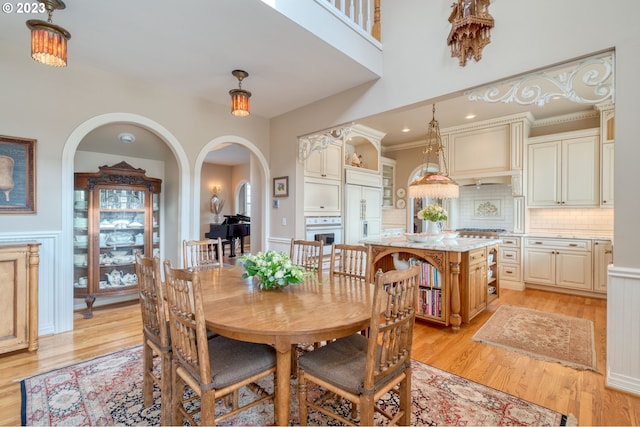 dining area featuring ornamental molding and light hardwood / wood-style flooring