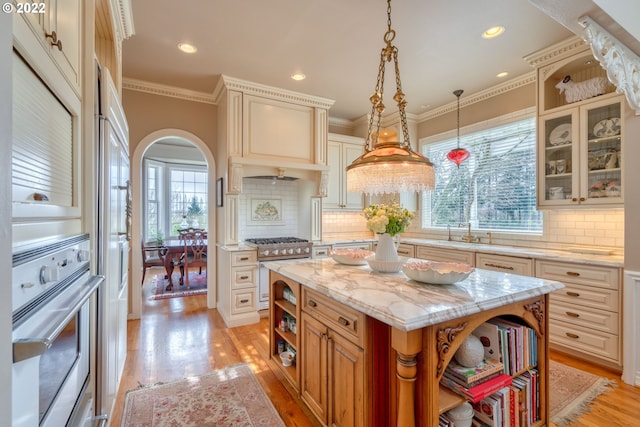 kitchen featuring backsplash, light hardwood / wood-style flooring, stainless steel appliances, and a center island