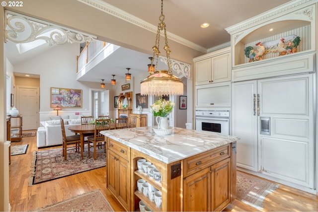 kitchen with a center island, a notable chandelier, light hardwood / wood-style floors, hanging light fixtures, and white oven