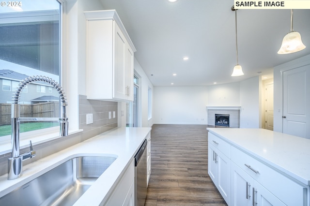 kitchen with dark hardwood / wood-style flooring, white cabinetry, sink, and hanging light fixtures