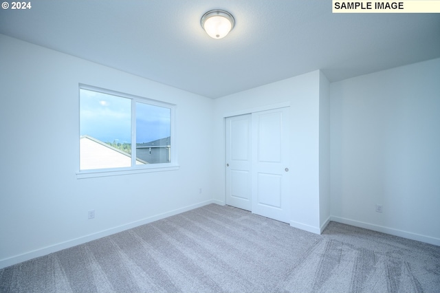 unfurnished bedroom with carpet and a closet