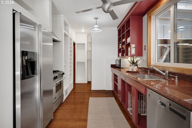 kitchen with stainless steel appliances, sink, ceiling fan, pendant lighting, and dark hardwood / wood-style flooring