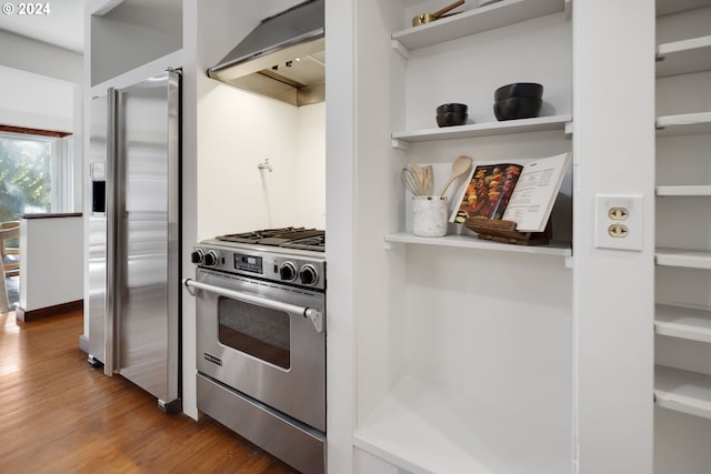 kitchen with stainless steel appliances, wood-type flooring, and extractor fan