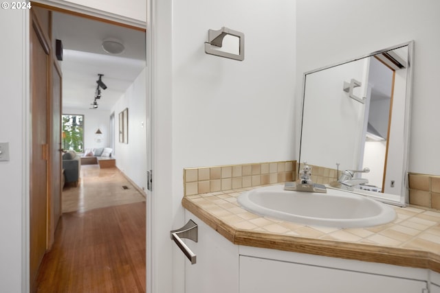 bathroom featuring vanity, hardwood / wood-style floors, and rail lighting