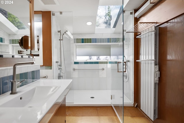 bathroom featuring lofted ceiling with skylight, vanity, tile walls, and a shower with shower door