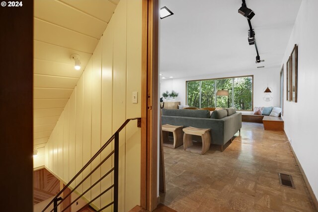 hallway with wood walls and vaulted ceiling