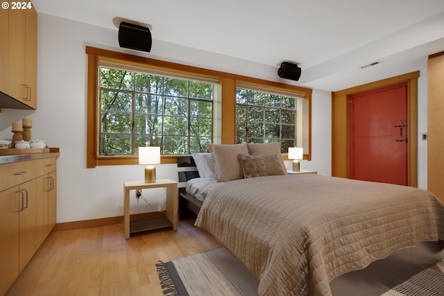 bedroom featuring multiple windows and light wood-type flooring